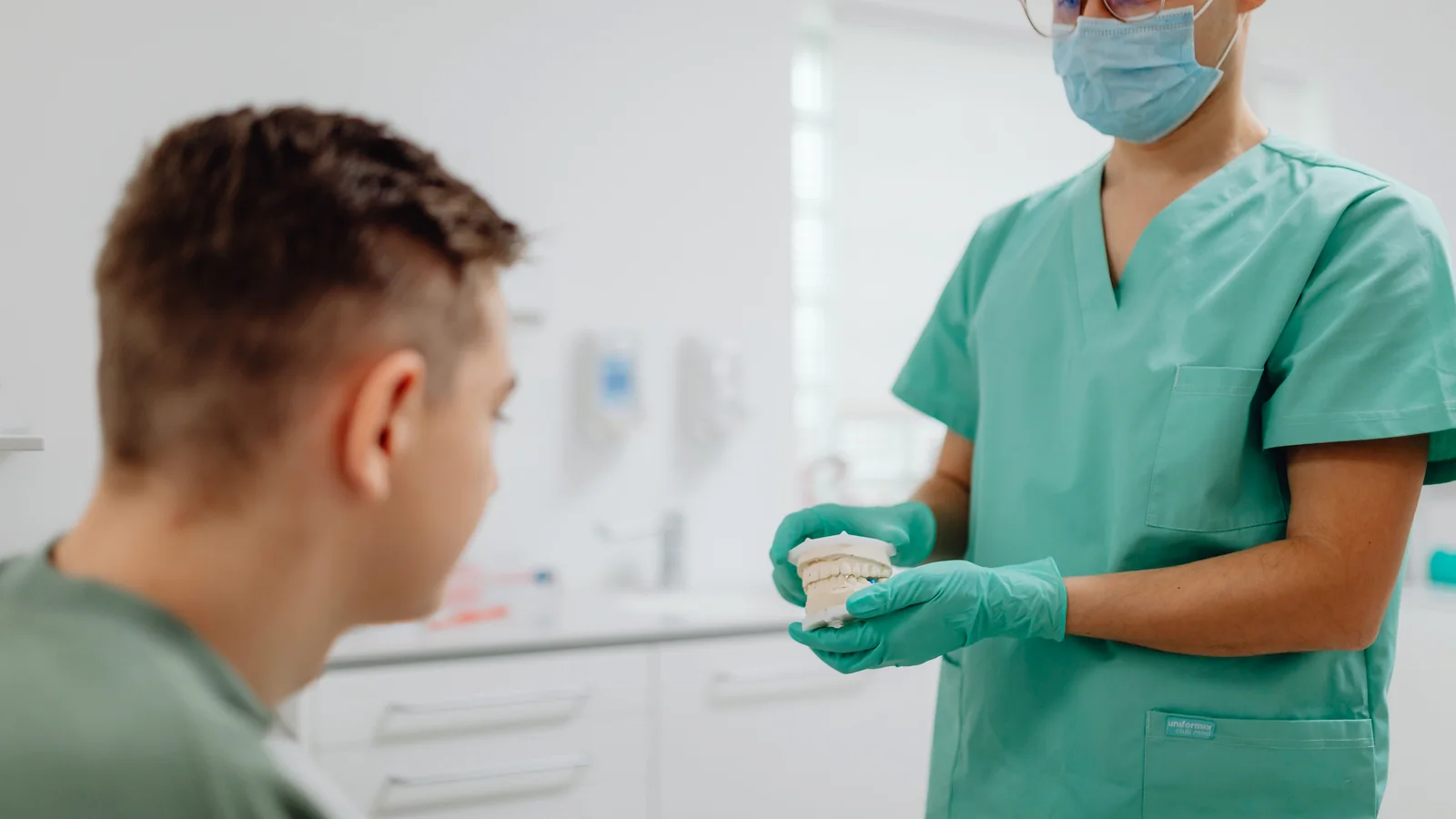 Dentist explaining oral care using a dental model